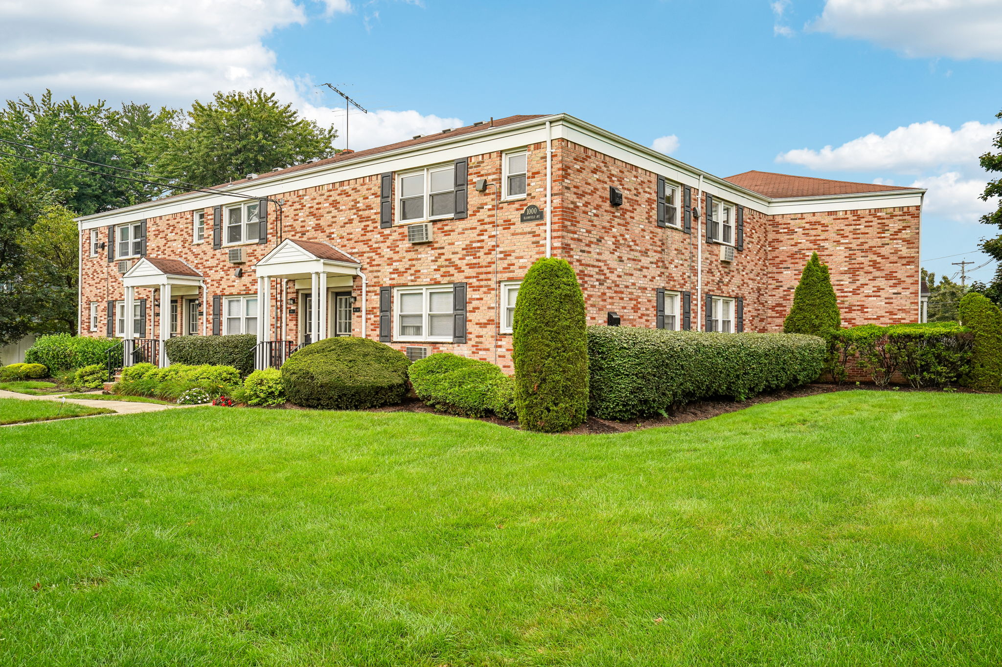 A brick house with a green lawn in front.